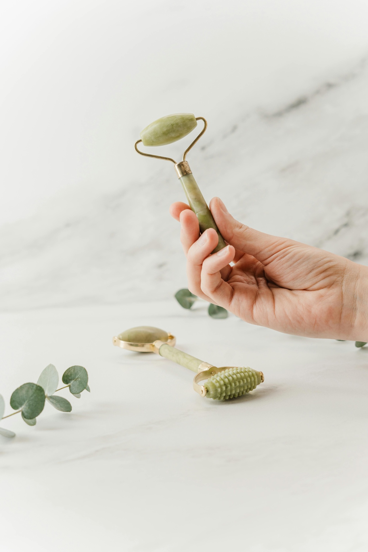 Woman using jade roller on cheek