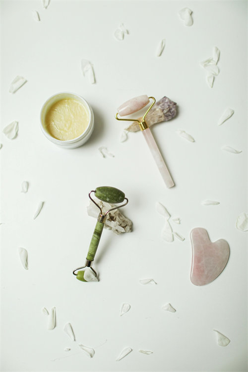 Jade roller stored near skincare products on a bathroom counter