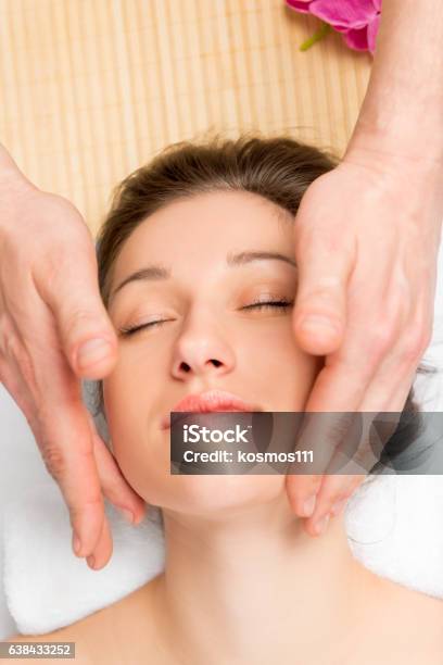 Hands performing facial massage technique on face