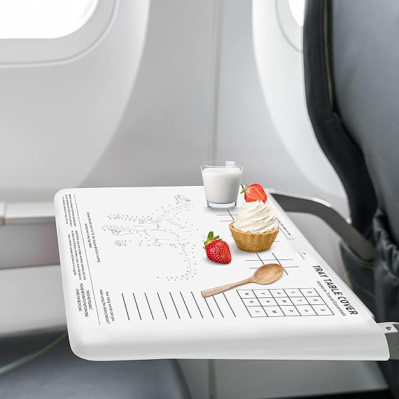 A jade roller and a mini skincare set on an airplane tray table