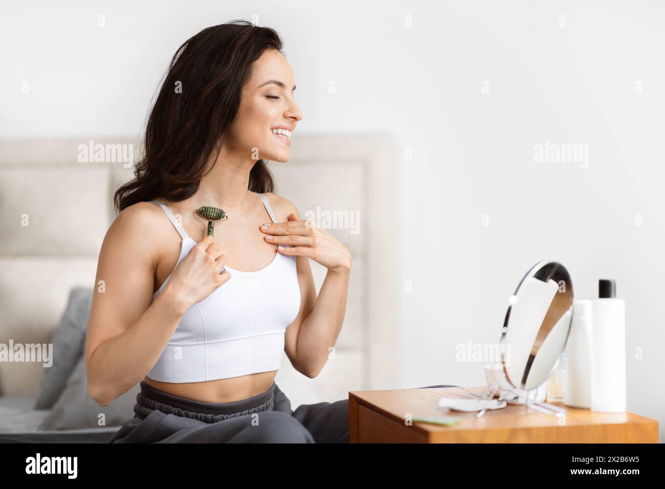 woman using jade roller bathroom